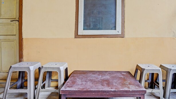A room with a wooden table and four plastic stools arranged around it. - Hotel O Lili Kost SyariahNearKetapang Royal City (Banyuwangi)