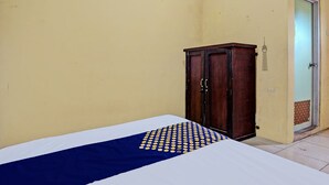 A room with a bed, a wooden wardrobe, and a door leading to a bathroom. - Hotel O Lili Kost SyariahNearKetapang Royal City (Banyuwangi)