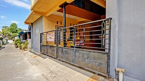 A building with a gated entrance, a signboard, and a paved pathway. - Hotel O Lili Kost SyariahNearKetapang Royal City (Banyuwangi)