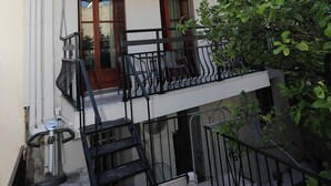 A two-story building with a balcony, a staircase, and a small outdoor area with a bicycle. - Angelina's House (Rethymno)