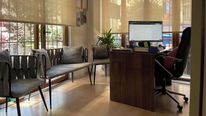 Una oficina moderna con escritorio, computadora y zona de estar.