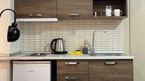 Una cocina moderna con armarios de madera, un hervidor de acero inoxidable, una cafetera y un lavavajillas.