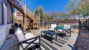 Une terrasse avec des meubles d’extérieur, une piscine et une plateforme en bois.