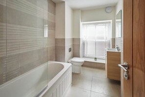 Bañera, secador de pelo, toallas y jabón