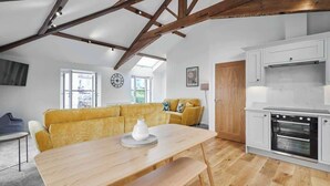 A modern kitchen with white cabinets, a built-in oven, and a wooden ceiling. - Host & Stay | 3 The Mount (Whitby)