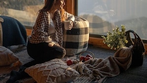 A cozy room with a large window, a checkered blanket, a mug, and a cushion. - Avalon Cottages Kanatal (Tehri)