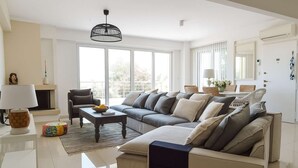 A modern living room with a sectional sofa, a coffee table, and a fireplace. - Beachfront Rio Escape - Luxurious Coastal Retreat (Rio Patras)