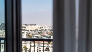 A view through a window of a cityscape with buildings and a hill with a dome. - Dreamy  2BDR, Unparalleled Views Of The Old City (Jerusalem)
