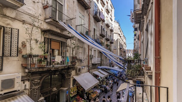 A narrow street with balconies, a market, and a pedestrian walkway. - Domus Partenopea  (Naples)