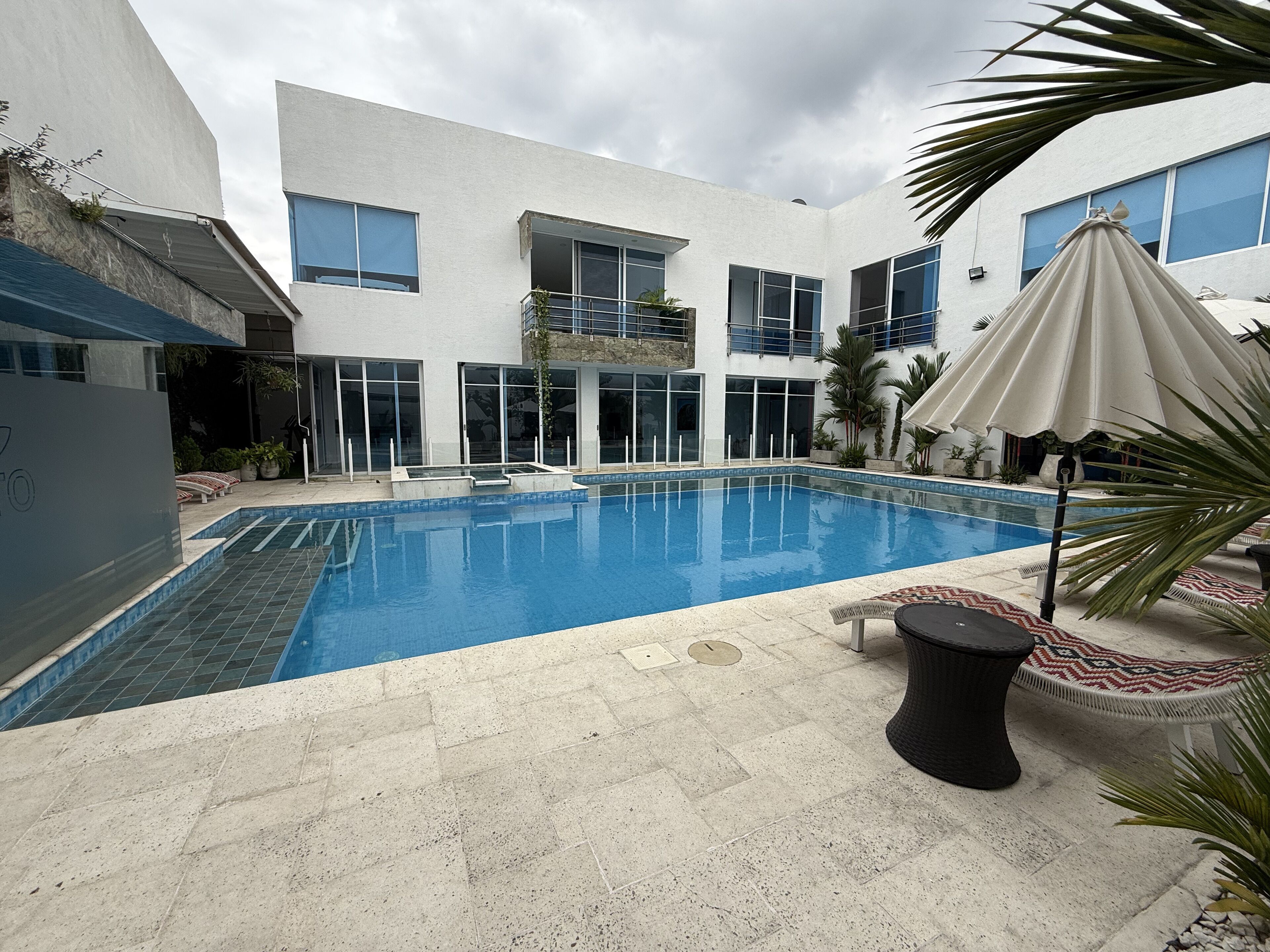 Alberca al aire libre, sombrillas en la alberca y camastros 