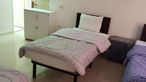 A bedroom with a bed, a bedside table, a dresser, and a window. - Wadi Musa (Wadi Musa)