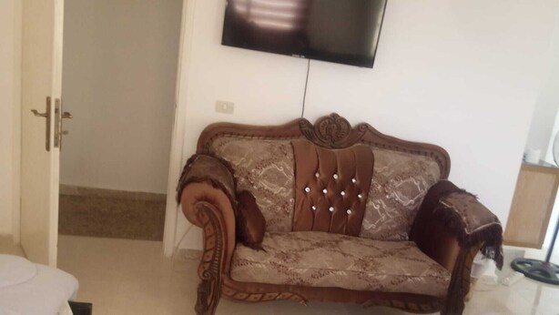 A room with a sofa, a television mounted on the wall, and a bed. - Wadi Musa (Wadi Musa)