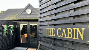 Una cabaña de madera con un letrero que dice "THE CABIN".