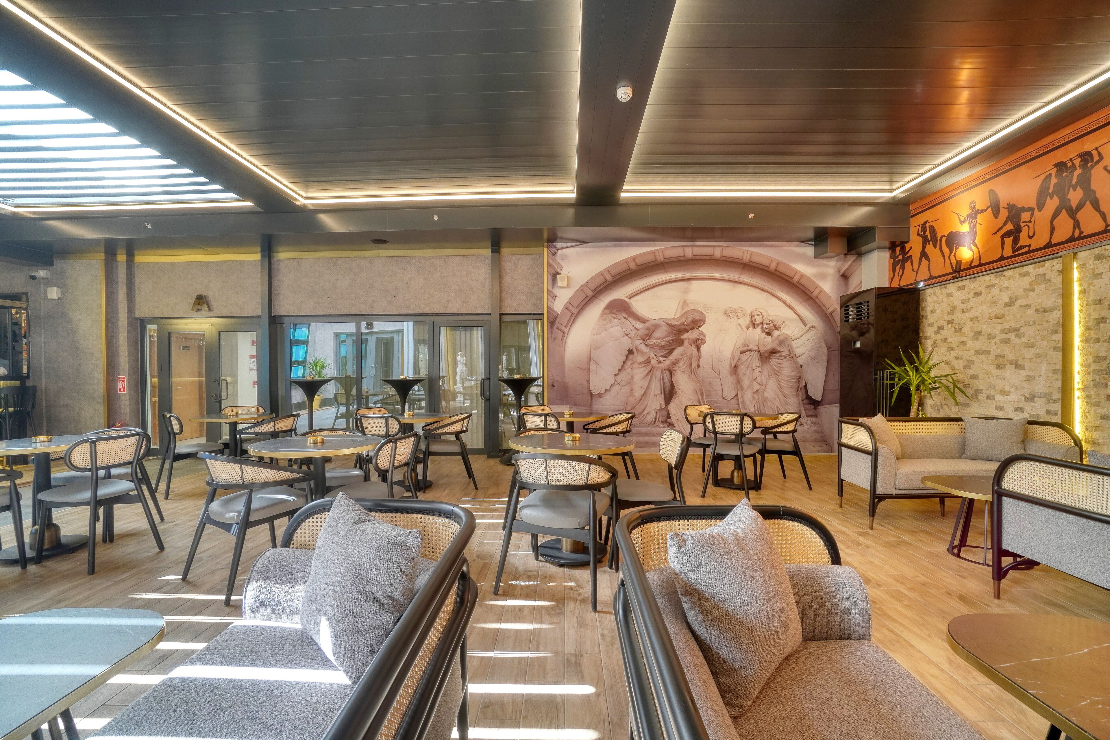 A modern interior with seating areas, a mural, and a reception desk.