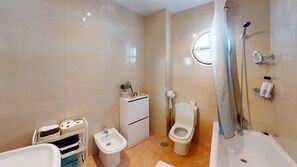 A modern bathroom with a bathtub, a bidet, a toilet, and a shower.