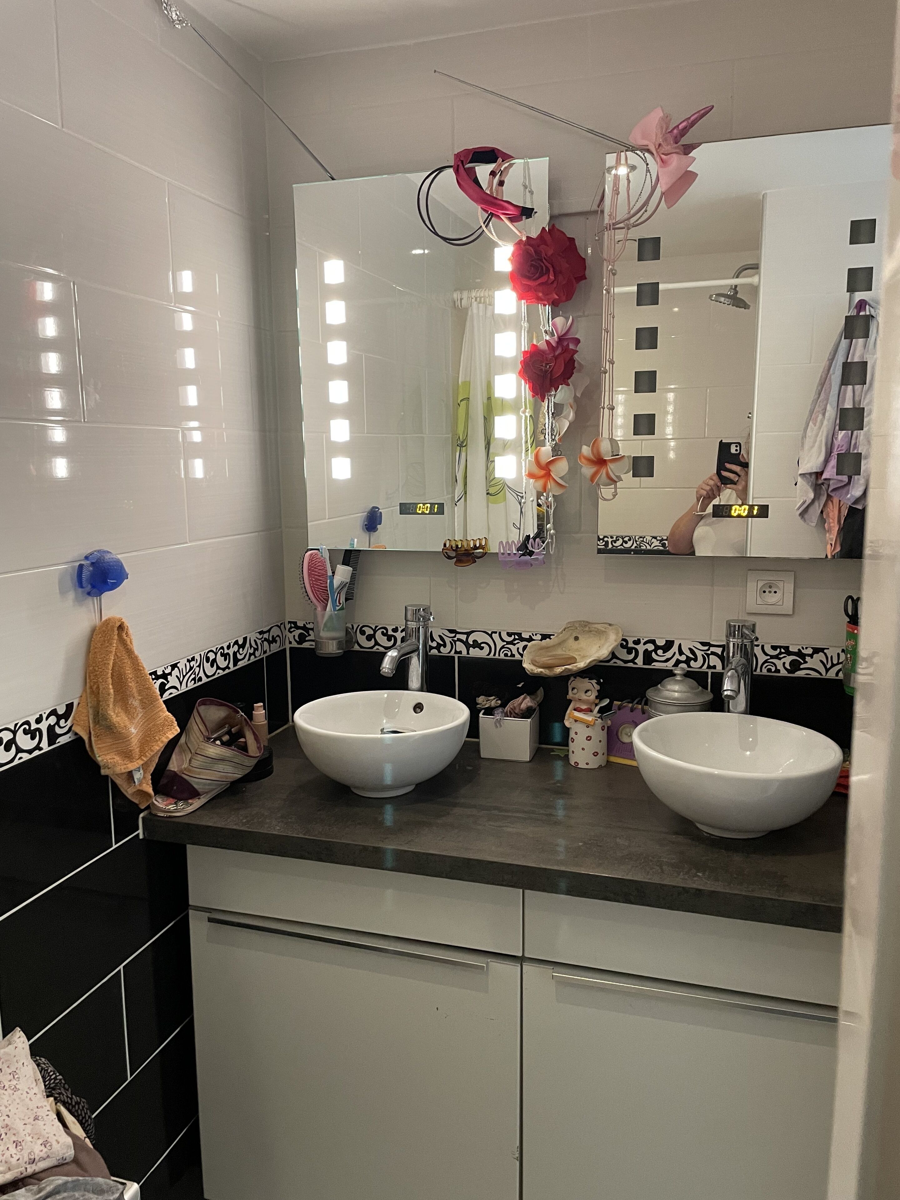 Un baño con dos lavamanos, un espejo y un perchero para toallas.