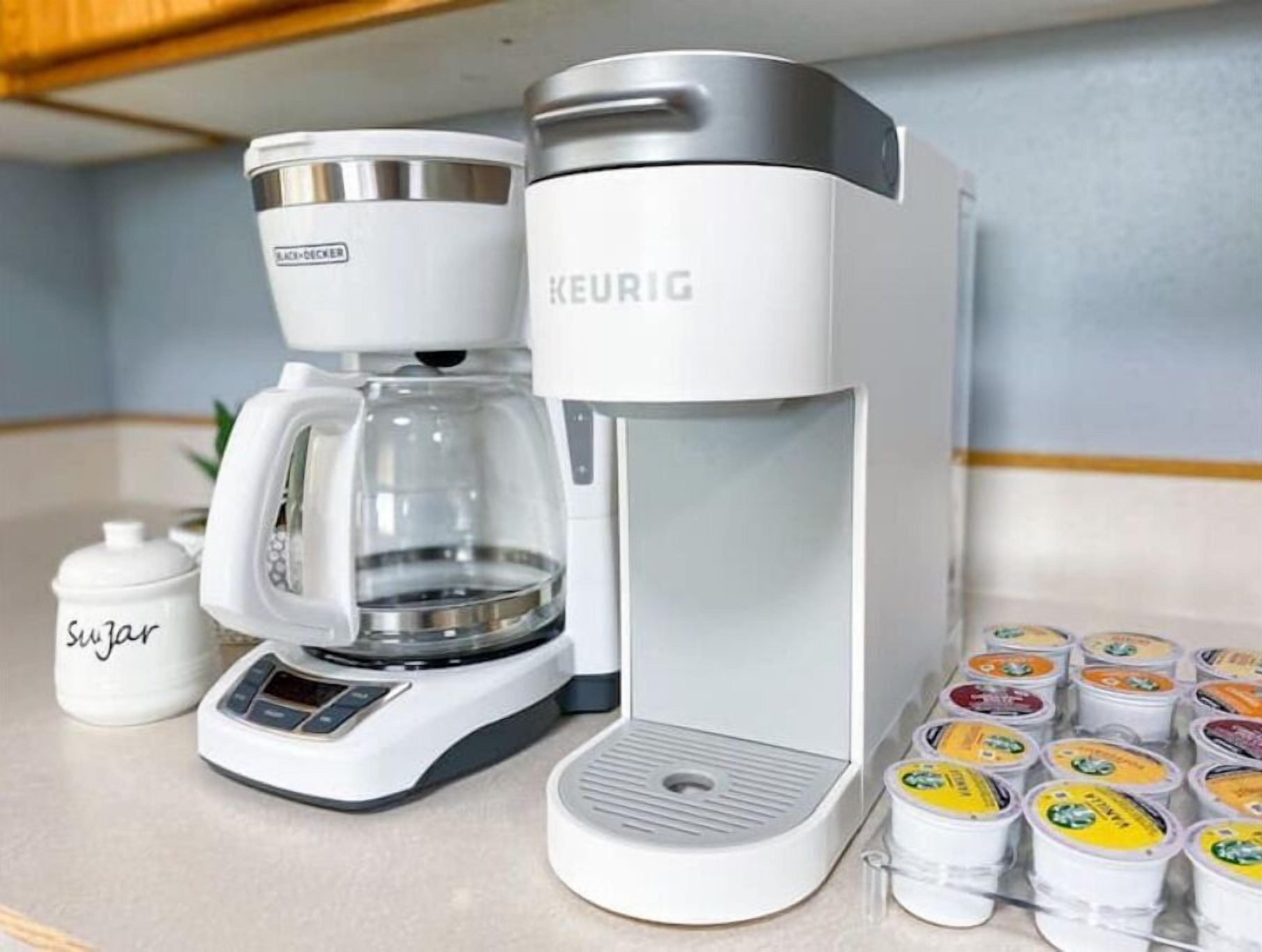 A coffee maker with a coffee pot and a sugar container on a kitchen counter.