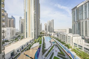 A high-rise residential building complex with multiple apartment buildings, a central courtyard with a swimming pool, and a well-maintained green space. - Yogi - Elegant Apartment With Balcony Amidst Vibrant Area (Dubai)