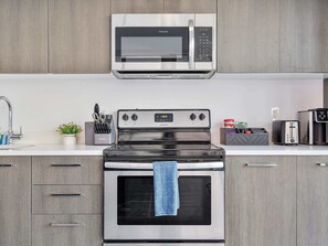 A kitchen with a stainless steel microwave, oven, and a toaster.
