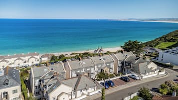 Un área residencial costera con casas, una playa y una vista despejada del mar.