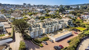 Zona residencial con casas adosadas, un estacionamiento y un edificio grande de techo plano.
