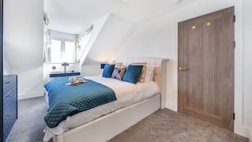 Ein Schlafzimmer mit Bett, Schminktisch, Fenster und Tür.