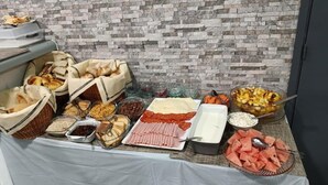 Ein Buffet mit verschiedenen Speisen, darunter Brot, Fleisch und Obst.