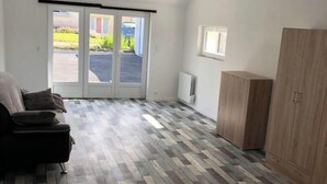 A room with a patterned floor, a sofa, a cabinet, and a sliding glass door leading outside.