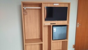 A wooden wardrobe with a flat-screen TV and a mini-fridge. - Pousada Ametista (Penha)