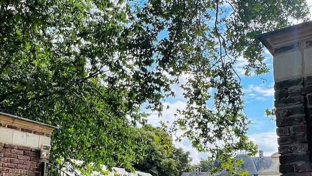 En innergård med en byggnad som har välvda fönster och en fasad av sten.