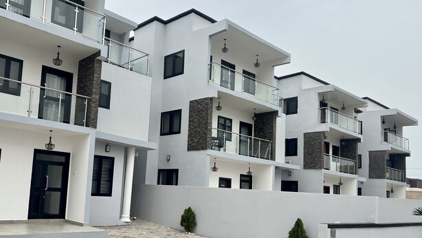 A modern multi-story residential building with balconies, large windows, and a clean, white exterior. - A Haven of Comfort in Labone, with easy access to essentials amenities (Accra)