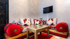 Una sala de estar moderna con un conjunto de sofá, una mesa de centro de vidrio y un televisor de pantalla plana montado en la pared.