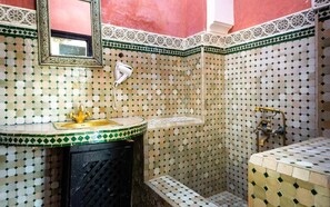 A bathroom with a tiled mosaic wall, a sink with a gold faucet, and a shower area. - Sidi Abdallah Ghiat (Sidi Abdallah Ghiat)