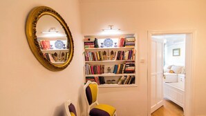 A room with a bookshelf, a mirror, and a bed. - Bozcaada Butik Pansiyon (Bozcaada)
