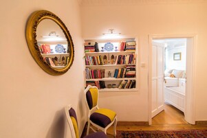Una habitación con estantería, espejo y cama.