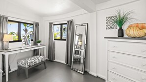 Un dormitorio moderno con cama, mesita de noche, lámpara y un espejo grande.