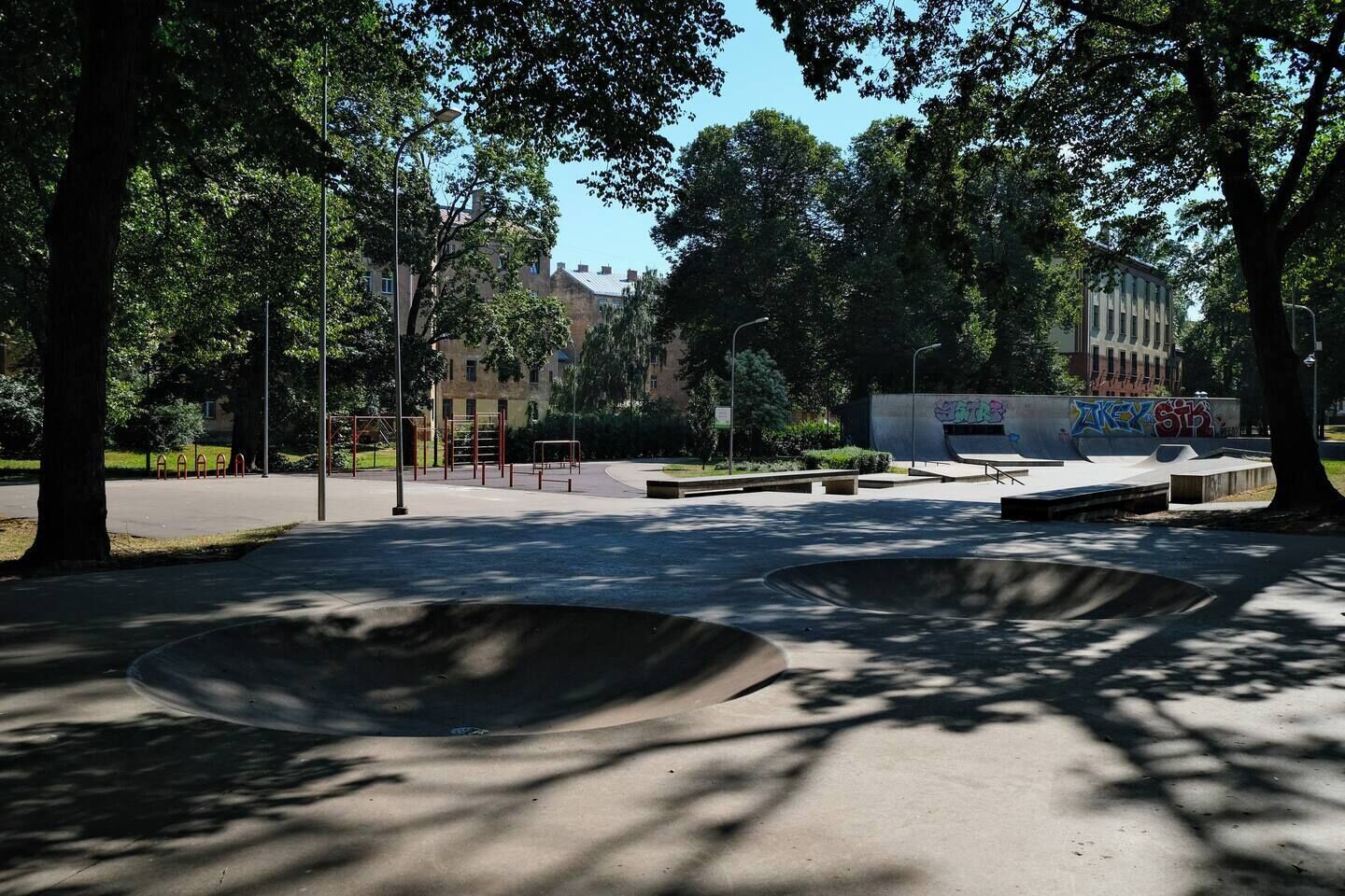 A park with skateboarding ramps and exercise equipment.