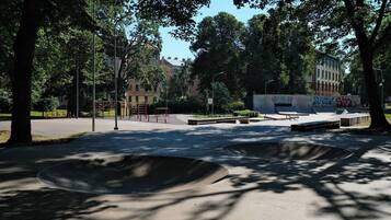 A park with skateboarding ramps and exercise equipment.
