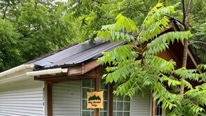 Een klein vakantiehuisje met een bordje waarop staat: 'Frog Mountain Cottage'.