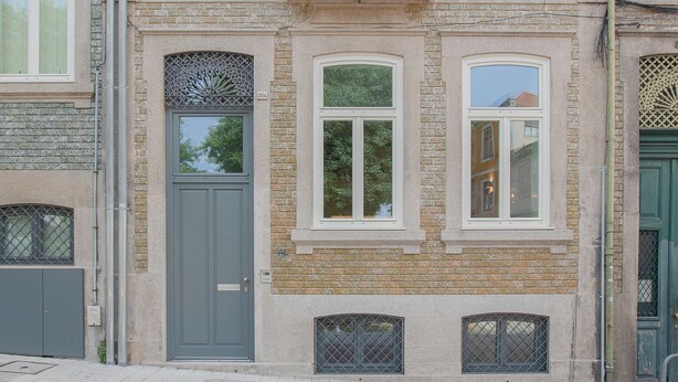 A multi-story building with a symmetrical facade, large windows, and a central balcony. - Liiiving in Porto - Haven Pool Apartment (Porto)