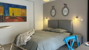 Une chambre moderne avec un grand lit, une chaise et un bureau.