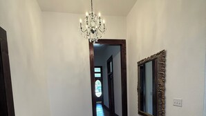 A hallway with a chandelier, a mirror, and a chair. - Plenty of space to relax! Near Turner falls, the lake & Crossbar Ranch. Sleeps 6 (Davis)
