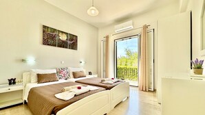 A modern bedroom with a large bed, a bedside table, a nightstand, a potted plant, and a view of the outdoors.