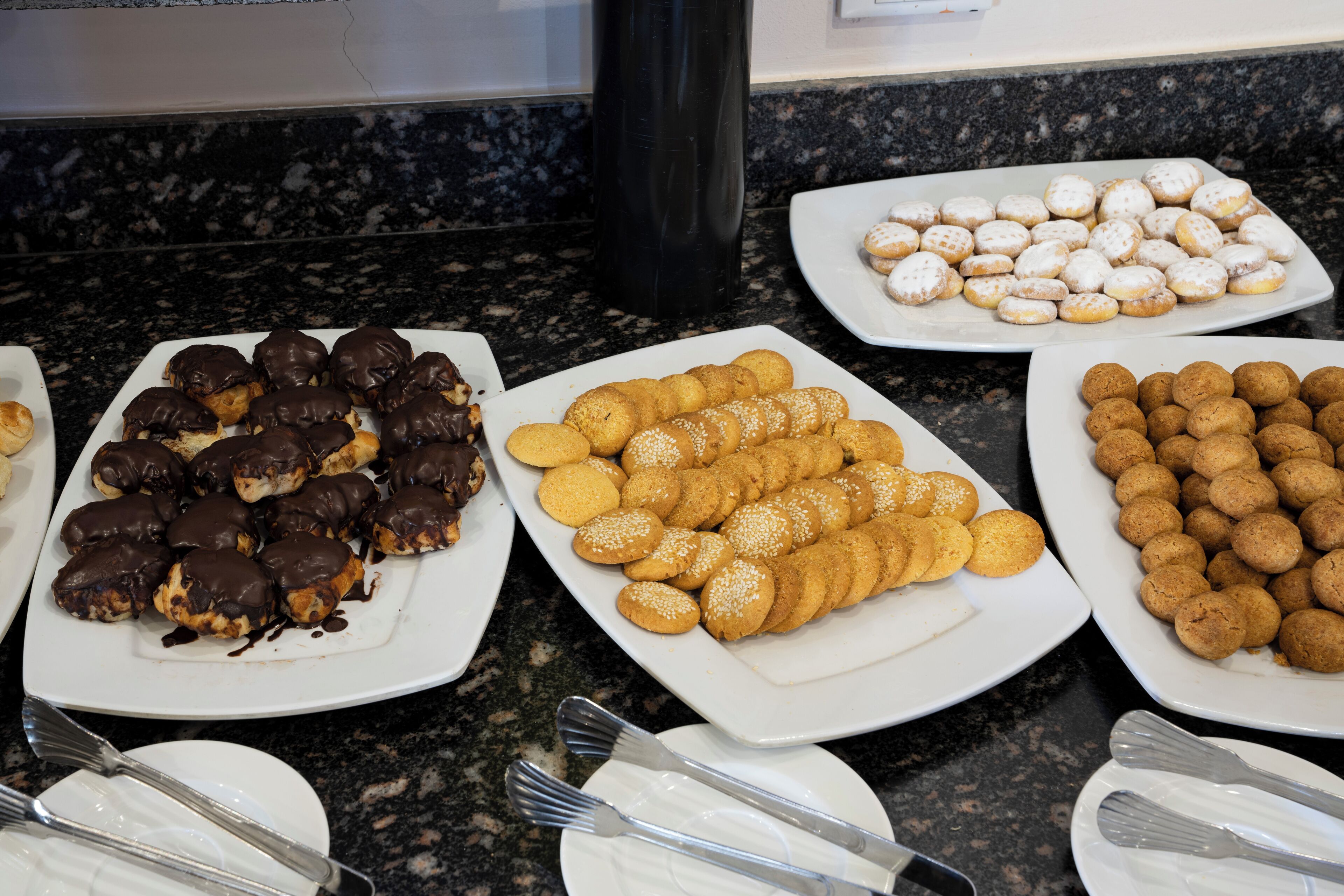 A buffet with various pastries and desserts arranged on plates.