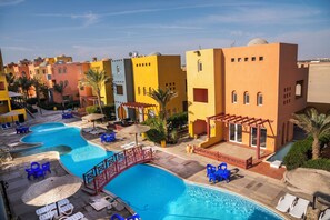 A resort with a swimming pool, sun loungers, and a covered patio area. - Aldora Residence suites (Hurghada)