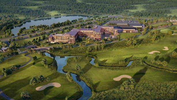 Un campo de golf con un gran complejo de edificios, que incluye numerosas habitaciones de hotel y una casa club.