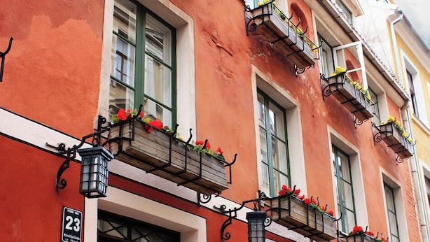 Un bâtiment rouge doté de nombreuses fenêtres et de balcons ornés de jardinières.