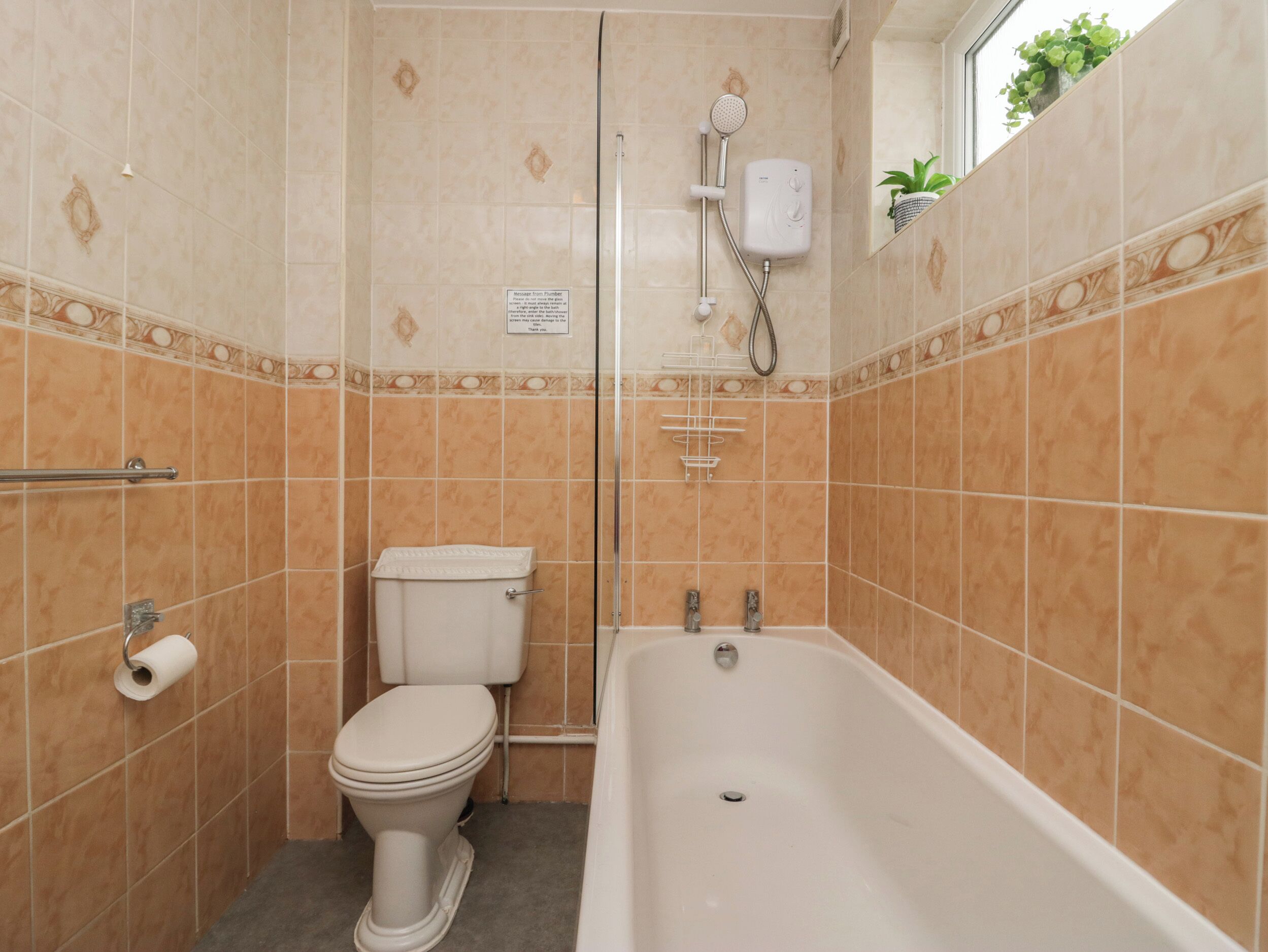 A bathroom with a toilet, a shower, and a bathtub.