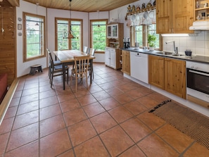 A kitchen with a dining table, chairs, and a sink. - Mustikka by Interhome (Kuusamo)