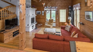 A cozy cabin-style room with a wooden interior, a sofa, a television, and a fireplace. - Mustikka by Interhome (Kuusamo)